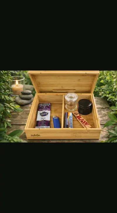 Open bamboo stash box with its lid raised, standing on a weathered wooden table outdoors with greenery behind