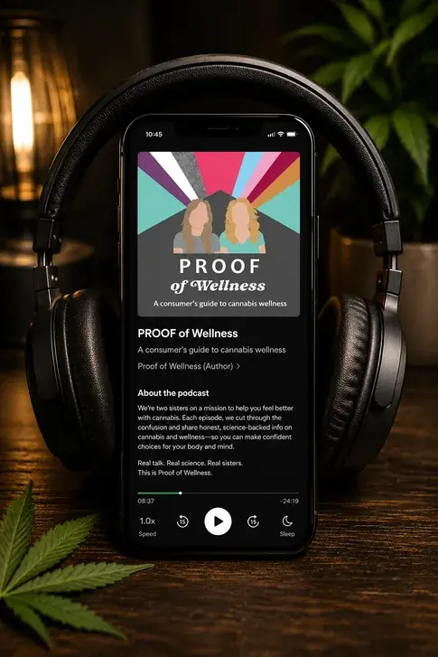 A phone propped against black over-ear headphones on a dark wooden table, its screen showing the Proof of Wellness podcast in a player with illustrated artwork, a progress bar and a play button