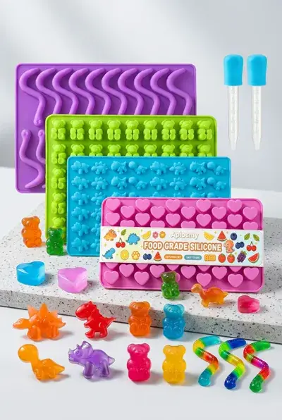A silicone gummy mold tray with small cavities and a filling dropper alongside