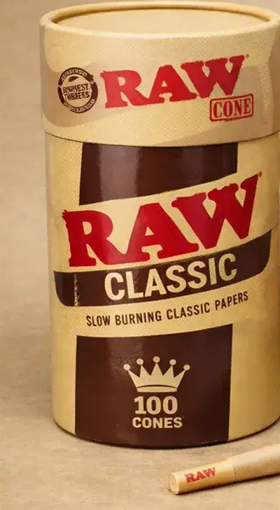Cardboard tube of king size pre-rolled cones with a loose cone and packing tube beside it